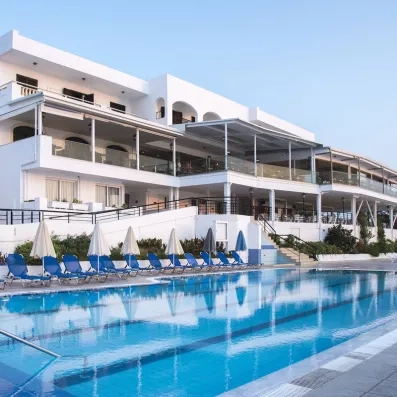 Vue générale de l'hôtel avec la piscine entourée des transats, le bâtiment et les terrasses