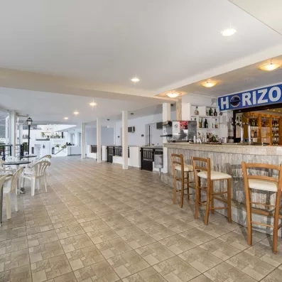 bar horizon avec des chaises hautes sur le comptoir et tables basses à la terrasse