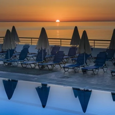 coucher de soleil depuis la terrasse qui contient les transats sur la mer