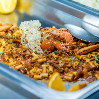 plat de pâtes sauce tomates avec des crevettes et du persil 