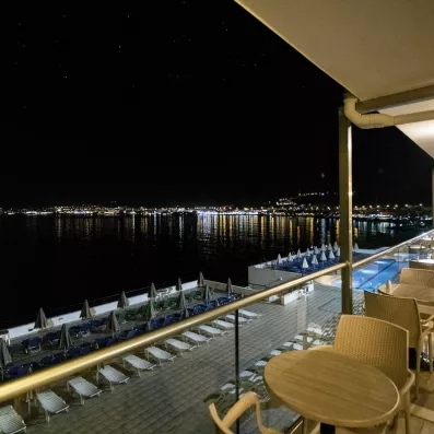 vue de nuit de la plage depuis la terrasse du restaurant avec des tables et chaises