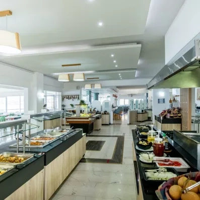 Salle de restaurant de l'hôtel avec un buffet bien garnis, plat et desserts