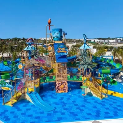 jeux aquatiques dans piscine, toboggans multicolores avec des palmiers, perroquet au sommet de l'aquapark