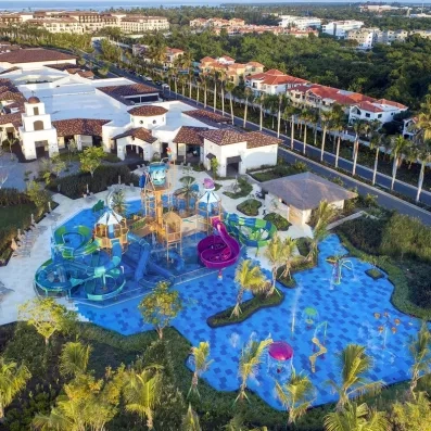 vue aérienne sur l'aquapark, toboggans et jeux d'eau, végétation luxuriante, petits bâtiments 