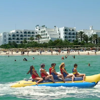 Groupe de touristes sur une bouée banane tractée devant l'hôtel Marhaba Beach à Monastir.