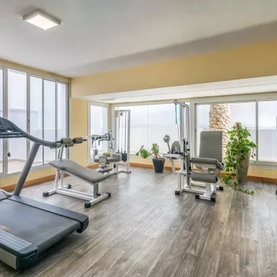 Salle de fitness lumineuse équipée de tapis de course et appareils de musculation au Marhaba Beach.