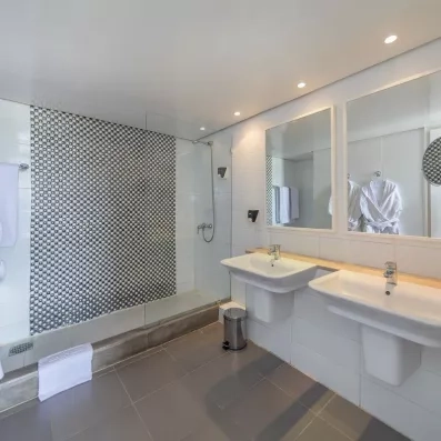 Salle de bain moderne avec douche à l'italienne et double vasque à l'hôtel Marhaba Beach Monastir.