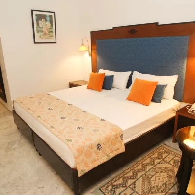 Lit double confortable et décoration chaleureuse dans une chambre standing de l'hôtel Marhaba Beach à Monastir.