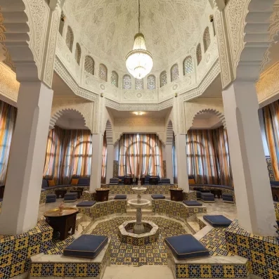 Salon de thé traditionnel tunisien avec fontaine centrale et architecture mauresque authentique au Marhaba Beach Monastir.