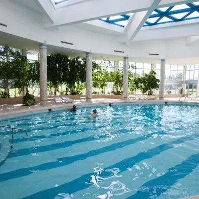 Grande piscine intérieure chauffée sous une coupole lumineuse pour un séjour détente au Marhaba Palace.