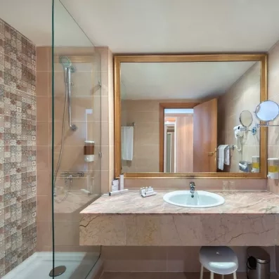 Salle de bain moderne avec douche à l'italienne et vasque en marbre à l'hôtel Marhaba Palace Monastir.