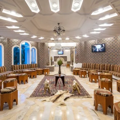 Salon de thé traditionnel tunisien avec tapis orientaux et décoration typique au Marhaba Palace à Monastir.