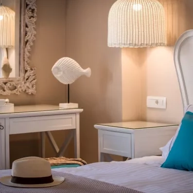 Chambre de l'hôtel avec une table de nuit, une coiffeuse et une lampe 
