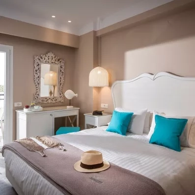 chambre avec 2 lits collés et grande tête de lit en blanc une porte fenêtre, et un climatiseur 