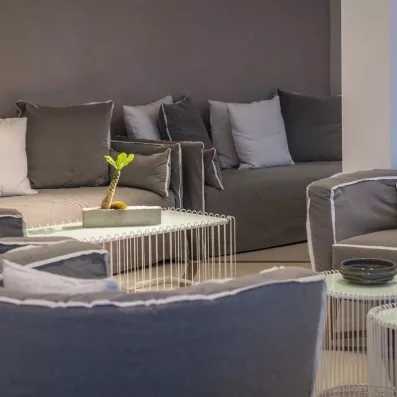 La réception avec fauteuil en gris et des tables basses en blancs