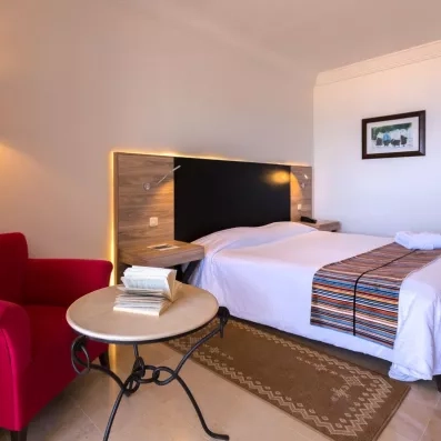 chambre avec table de chevet et fauteuil rouge 