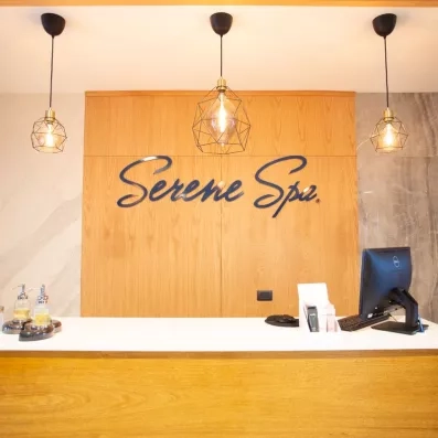 comptoir centre de spa réception, ordinateur et clavier et souris, trois luminaires 