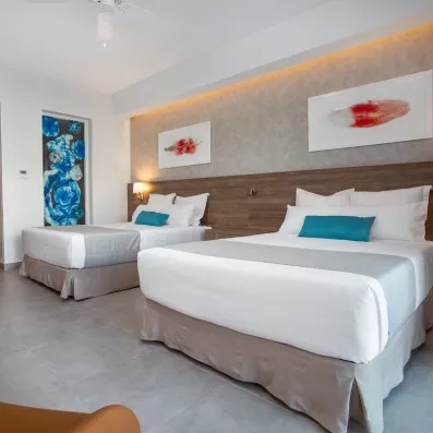 chambre 2 lits, tête de lit en bois, tableaux de peinture, vitre de la douche avec des peintures décoration sous marine