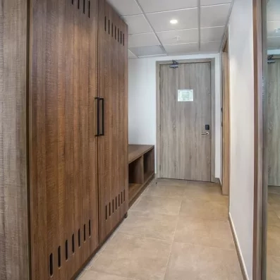 couloir de chambre, grande armoire en bois, emplacement pour mettre les chaussures, et grand miroir