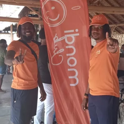 deux animateurs avec drapeau mondi club et tee shirts et casquettes oranges mondi club