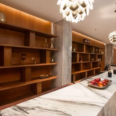 réception, étagères en bois et petites sculptures d'animaux, plateau de pommes rouges, lustres en forme de lotus