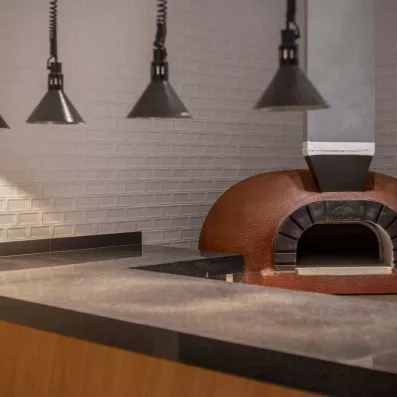 four à pizzas, plan de travail gris foncé, lampes au plafond 