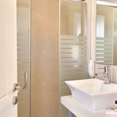 salle de bain avec lavabo en marbre blanc et un miroir accroché 