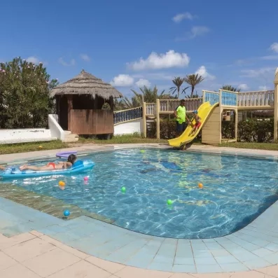 Piscine pour enfants avec toboggan jaune, jeux aquatiques et ambiance familiale.