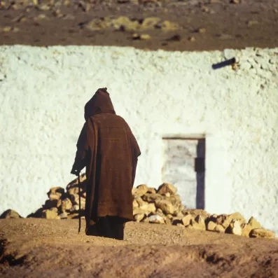 Rencontre authentique avec un habitant en tenue traditionnelle près des habitations troglodytes du village de Chenini.