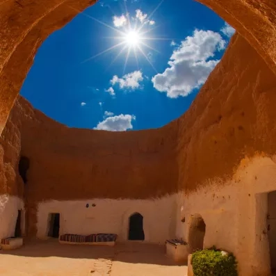 Architecture souterraine typique de Matmata avec vue sur le ciel bleu depuis le patio d'un cratère.