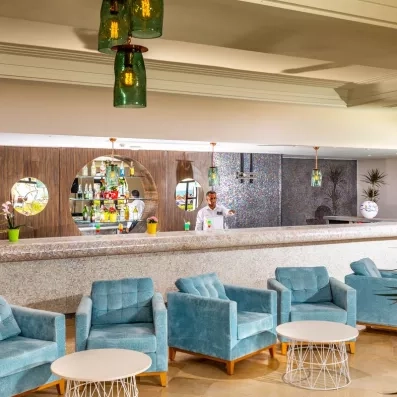 Bar élégant de l'hôtel Ulysse Djerba proposant des cocktails colorés dans un cadre chic et décontracté.