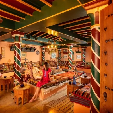 Café maure traditionnel à l'hôtel Ulysse Djerba avec colonnes colorées et ambiance orientale authentique.