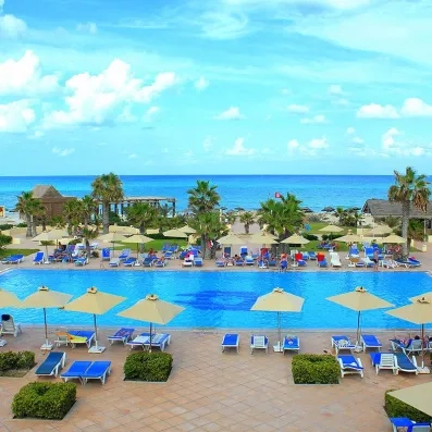 Vue panoramique sur la piscine principale et la plage privée du Vincci Dar Midoun à Djerba.