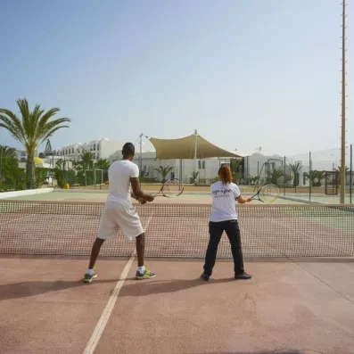 Séance de tennis en plein air sous le soleil de Djerba au complexe hôtelier Helios Beach.