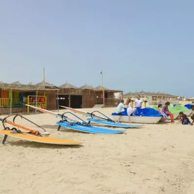 Activités nautiques et pédalos sur la plage de sable fin de l'hôtel Helios Beach à Djerba.