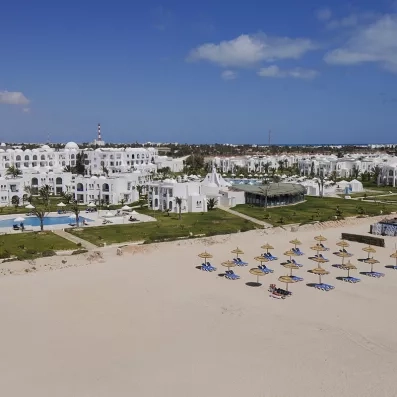 Vue aérienne du complexe hôtelier Helios Beach à Djerba, entre jardins verdoyants et plage de sable fin.