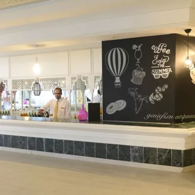 Bar moderne de l'hôtel Helios Beach à Djerba proposant des cocktails et rafraîchissements dans une ambiance décontractée.
