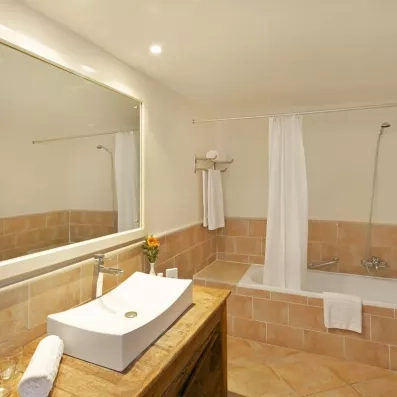 Salle de bain moderne et lumineuse avec baignoire, vasque design et carrelage typique de l'hôtel Safira Palms.