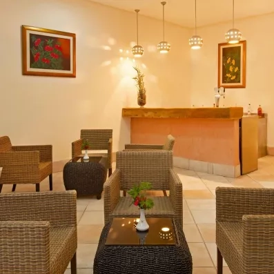 Bar intérieur convivial avec fauteuils en rotin et éclairage tamisé pour une soirée détente à Djerba.