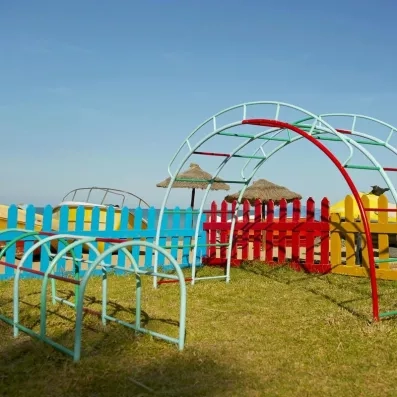 Aire de jeux extérieure pour enfants avec structures colorées et vue sur mer à Djerba.