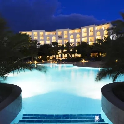 piscine extérieure de nuit avec bâtiment éclairé