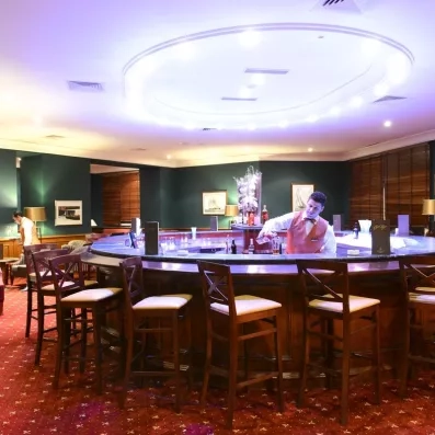 bar rond avec barmaid qui sert un verre 