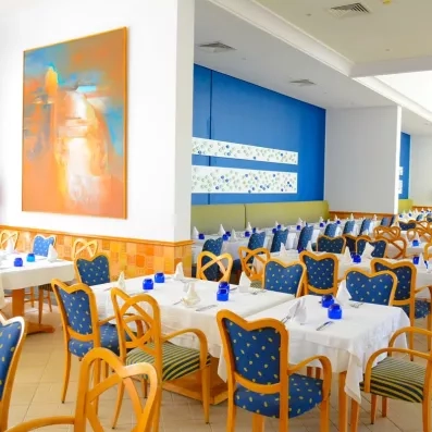 salle de restaurant avec nappe blanche et chaises bleu