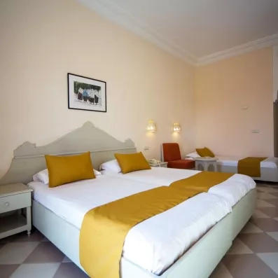 Chambre triple spacieuse à l'hôtel Zephir Djerba avec décoration typique et lits confortables pour familles.