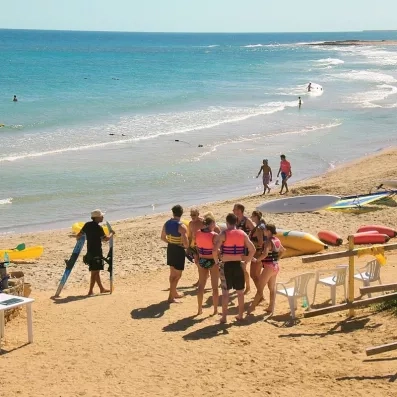Groupe de touristes préparant une activité de kayak sur la plage de sable fin de l'hôtel Zephir.