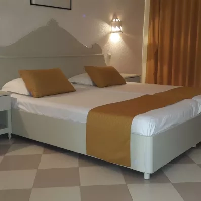 Chambre double élégante avec lit king size et touches de jaune moutarde à l'hôtel Zephir Tunisie.