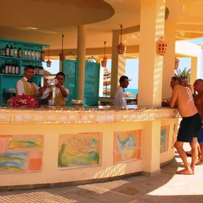 Bar extérieur convivial proposant des rafraîchissements aux vacanciers sous le soleil de l'hôtel Zephir.