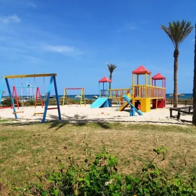 Aire de jeux extérieure pour enfants située sur la plage de l'hôtel Zita Beach Resort.