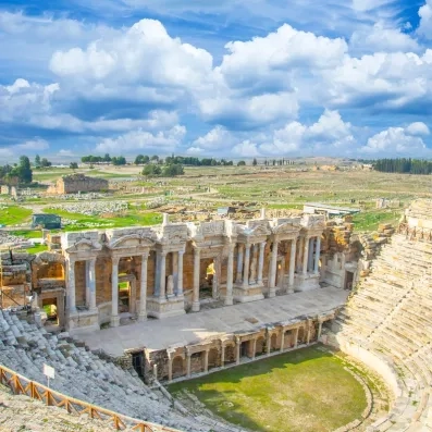 théâtre antique en pierre avec vue sur une colline 