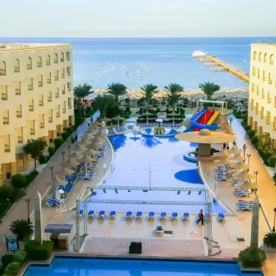 Grande piscine extérieure avec toboggans et parasols à l'hôtel AMC Royal Hotel à Hurghada, Égypte.